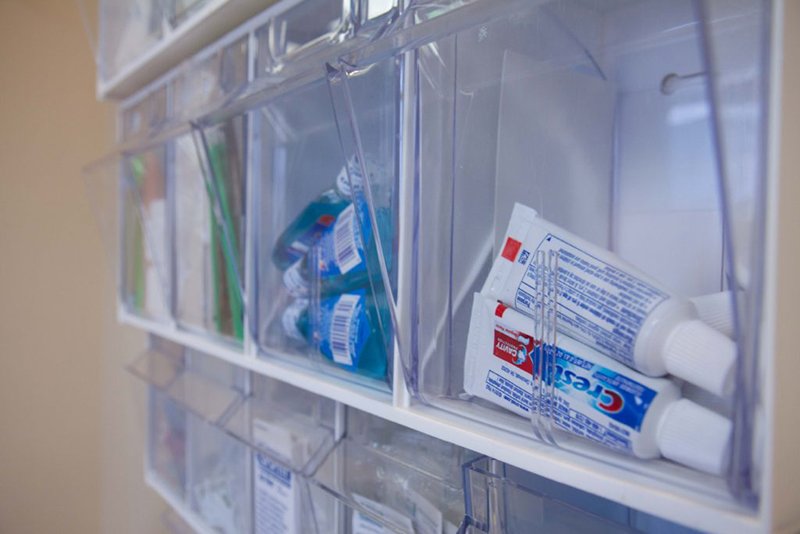 Close up shot of on-wall storage of dental samples including mouthwash and toothpaste